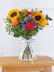 Colour Burst Vase – Brighten up any room with our "Colour Burst" arrangement, featuring stunning sunflowers, cerise carnations,...