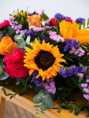 Colour Burst Spray – This stunning arrangement, bursting with vibrant hues of sunflowers, orange roses, yellow roses, pink...