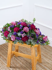 Purple Majesty Spray – A comforting blend of purple roses, statice, carnations, and delicate foliage, this floral arrangement...