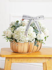 Sympathy Pure Bliss Basket –  A graceful composition of white roses, carnations, and hydrangeas, artfully arranged in a rustic...
