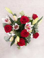Sympathy Red Roses and Pink Lily in a vase – A tender fusion of red roses and pink lilies, harmoniously nestled in a glass...