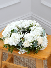 Pure Bliss Wreath – This enchanting funeral wreath, embellished with pristine white hydrangeas, roses, carnations, gypsophila, and accented...