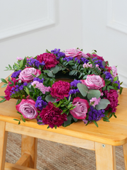 Purple Majesty Wreath – This Purple Majesty Wreath, adorned with exquisite purple roses, pink chrysanth, lilacs, blue statice,...