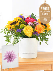 Colour Burst - Hatbox with Free Occasion Card –  Brighten up any room with our "Colour Burst" arrangement, featuring stunning sunflowers, cerise carnations,...