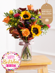 Birthday Autumn Charm - Vase (Complimentary Birthday Balloon) –  Brighten up their special day with our Autumn Charm - Vase arrangement, featuring stunning sunflowers,...