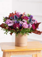 Autumn Purple Majesty Hatbox – Experience autumn's beauty with our Autumn Purple Majesty arrangement, featuring purple roses, purple carnations, thistles,...