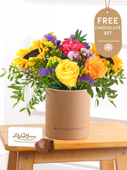 Colour Burst - Hatbox with Free Chocolate Set – Brighten up any room with our "Colour Burst" arrangement, featuring stunning sunflowers, cerise carnations,...