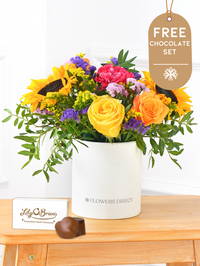 Colour Burst - Hatbox with Free Chocolate Set – Brighten up any room with our "Colour Burst" arrangement, featuring stunning sunflowers, cerise carnations,...