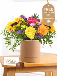 Colour Burst - Hatbox with Free Chocolate Set – Brighten up any room with our "Colour Burst" arrangement, featuring stunning sunflowers, cerise carnations,...