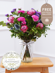 Anniversary Purple Majesty - Vase with Free Anniversary Balloon –  Experience the regal and majestic beauty of our "Purple Majesty" arrangement, featuring luxurious deep...