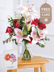 Anniversary Red Roses and Pink Lily - Vase with Anniversary Card –  This is a very elegant bouquet, featuring large headed Naomi Red roses with scented...